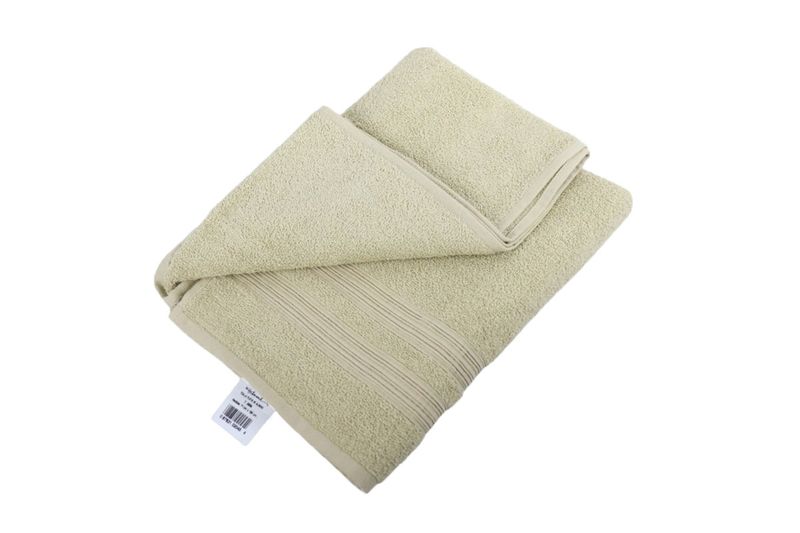 Toalla 71 x 130 cm almond 70 playa Home Collection Hilasal, doblada en ángulo cenital mostrando la etiqueta blanca