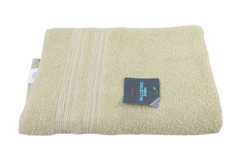 Toalla 71 x 130 cm almond 70 playa Home Collection Hilasal, doblada con etiqueta negra de la colección sobre la tela