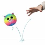 Peluche gatita multicolor Ty, juguete esférico saltando sobre una superficie con una mano intentando atraparlo