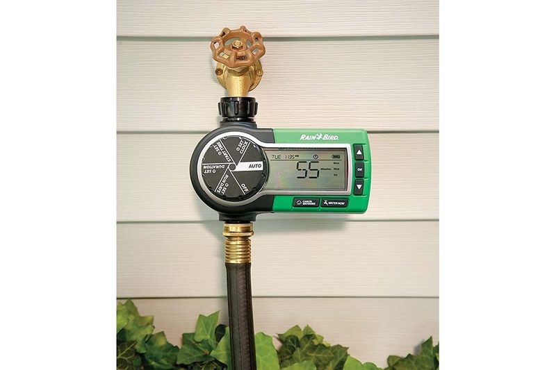 Kit aspersores timer tubos y conectores Rain Bird, primer plano del temporizador digital verde instalado en grifo
