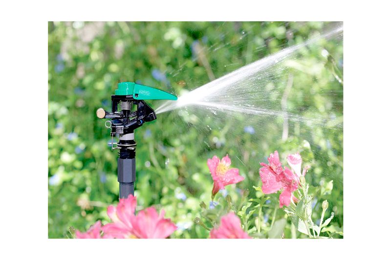 Cabeza para aspersor de impacto sprinkler 3 pulgadas 360° Rain Bird, en funcionamiento regando flores en el jardín