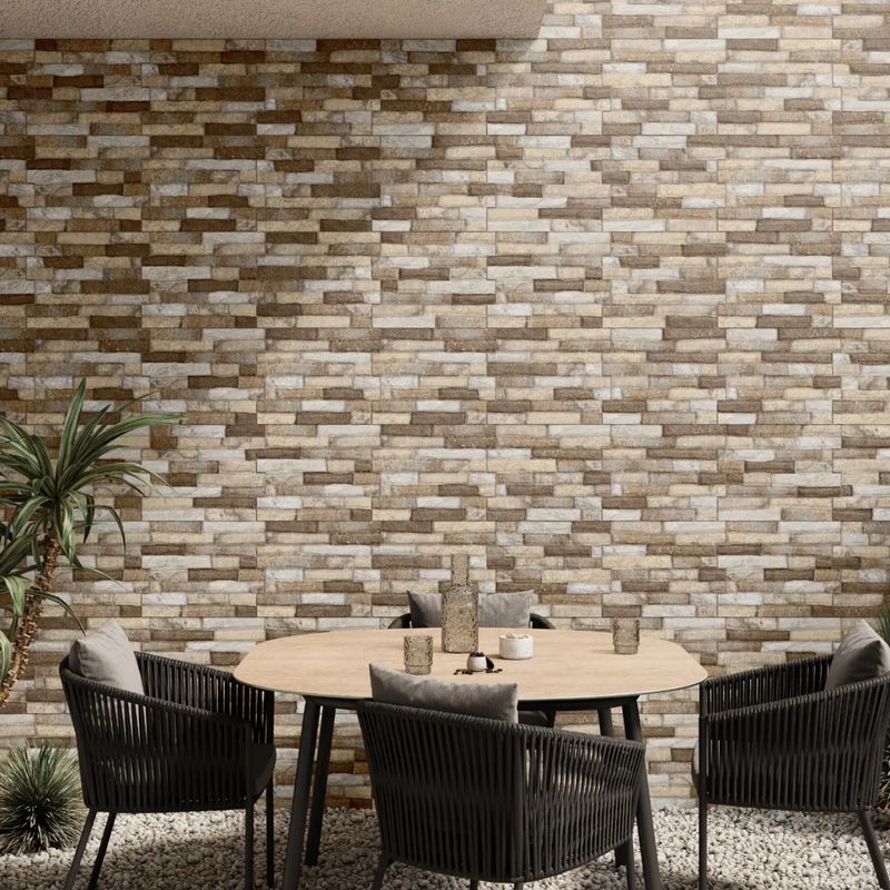 Fachaleta 30x45 Dent Gianna Stone FD Mix café Porcelanite, instalada en muro exterior con mesa y sillas de terraza