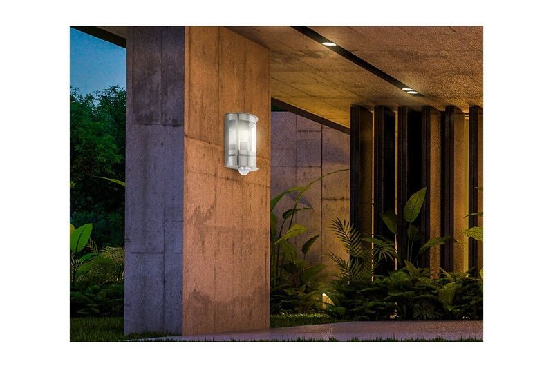 Lámpara de pared exterior con sensor Tribano acero zincado plateado E27 IP44 Eglo, instalada y encendida en una pared