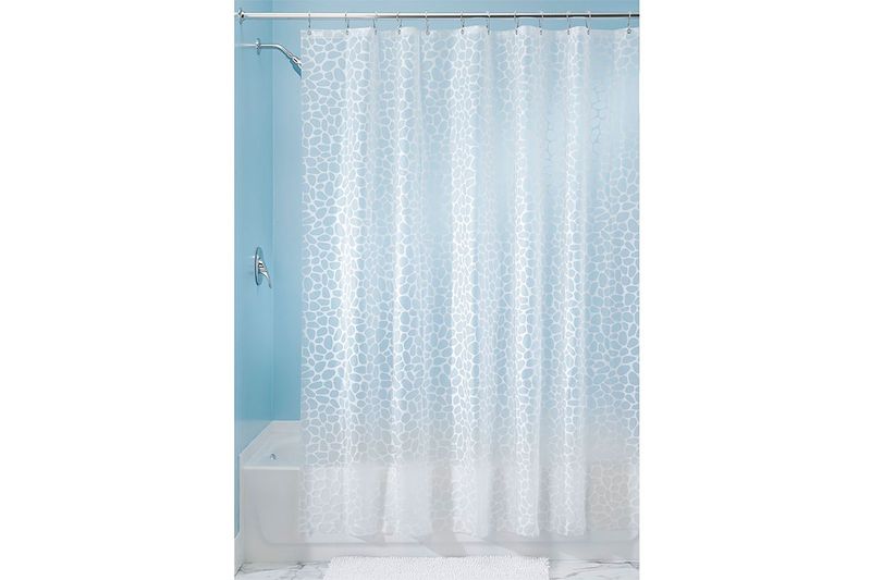 Cortina de baño plástica Pebblz blanca Interdesign, extendida en el tubo de la ducha con patrón de círculos irregulares