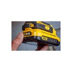 Taladro inalámbrico 1/2 pulgada V20 Stanley, primer plano de la batería de litio amarilla y negra sostenida por una mano