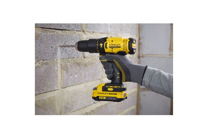 Taladro inalámbrico 1/2 pulgada V20 Stanley, siendo utilizado por una persona para perforar una pared de bloques