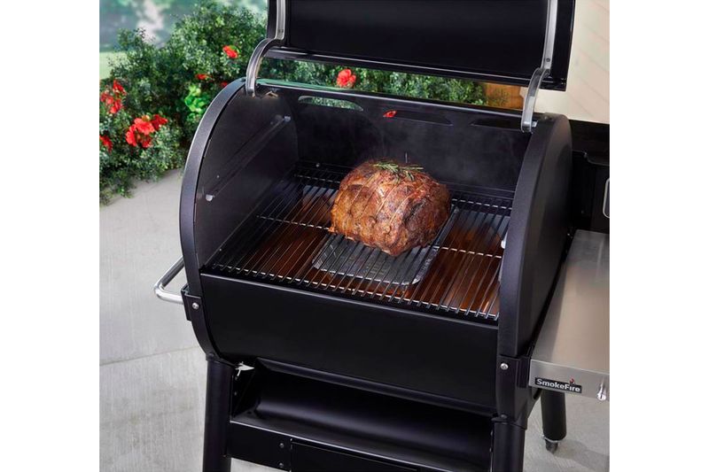 Kit de ahumado 4 piezas Weber, pieza de carne cocinándose sobre la rejilla dentro de una parrilla negra SmokeFire