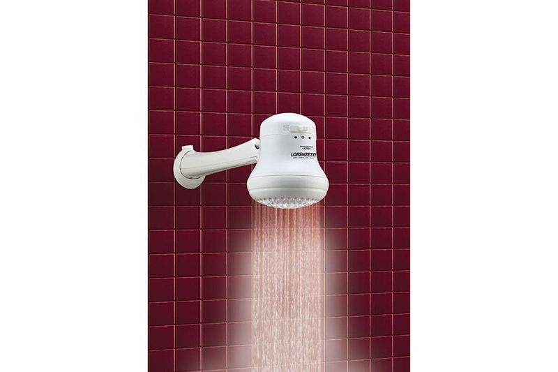 Ducha eléctrica Maxi Ducha 3T Ultra blanca sin manguera 127V/5500W Lorenzetti, instalada en pared roja soltando agua