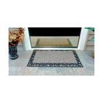 Alfombra entrada con borde marrón topo 18 x 30 pulgadas GrassWorx, colocada en el piso frente a una puerta de vidrio