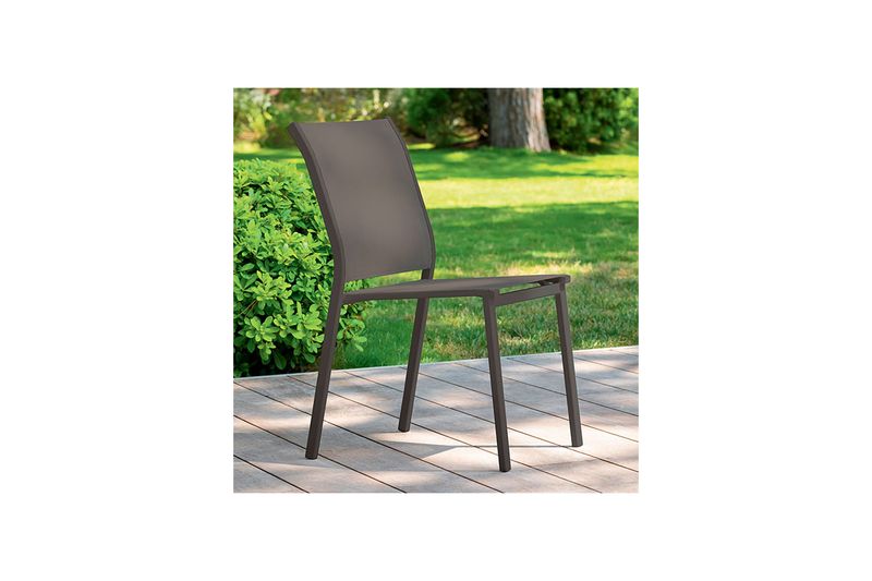 Silla apilable Essentia wenge Hespéride, vista lateral en exterior sobre terraza de madera y jardín
