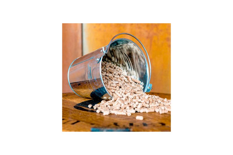 Pellets de madera manzana-cerezo-roble 20 lb Traeger, derramándose desde un balde metálico sobre una superficie de madera