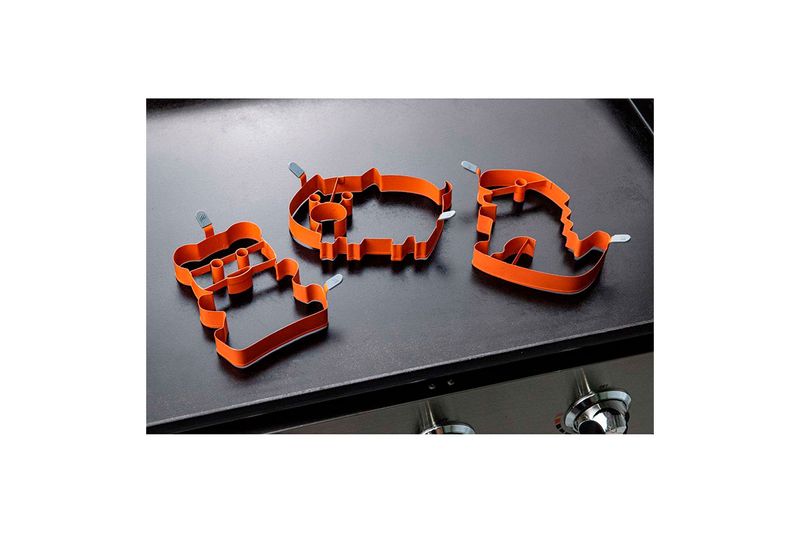 Kit de arte pancake Blackstone, tres moldes naranjas con formas sobre una plancha negra