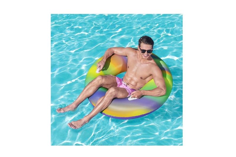 Flotador ring rainbow 47 pulgadas Bestway, hombre usando el aro inflable multicolor sobre el agua de una piscina