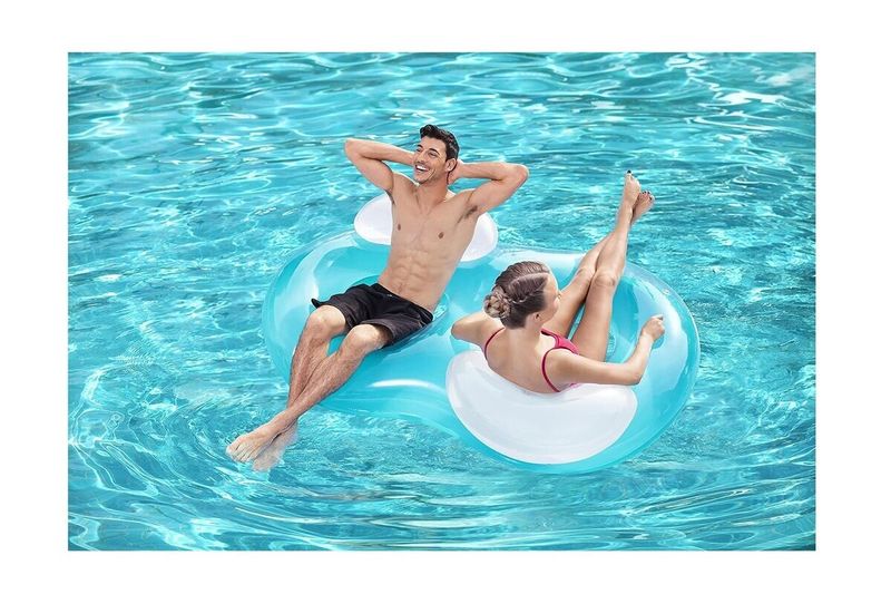 Flotador doble anillo 1.88 m x 1.17 m Bestway, hombre y mujer usándolo en una piscina de agua cristalina