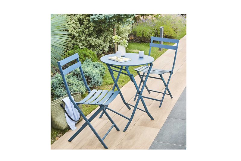 Set mueble Greensboro folding redondo azul 3 pza Hespéride, mesa y dos sillas en jardín con tazas sobre el tablero