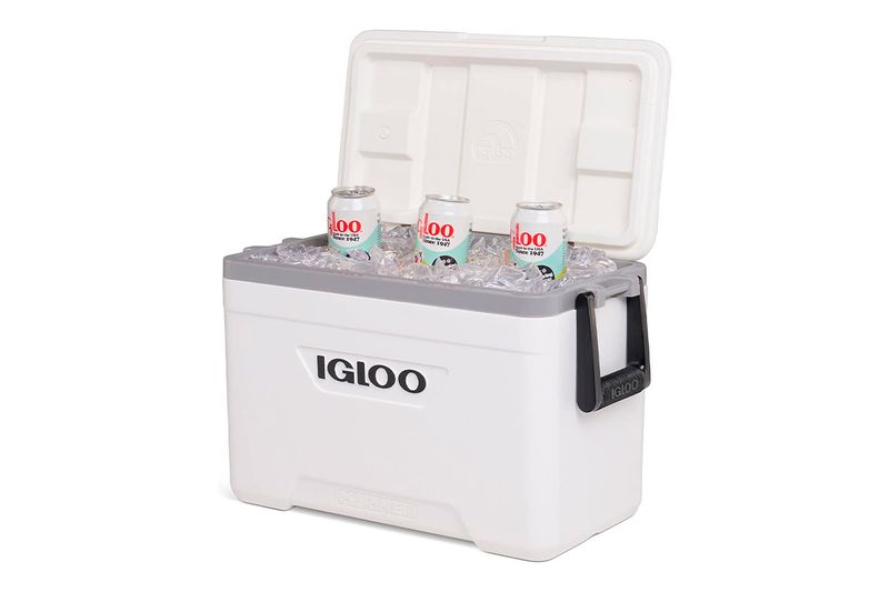 Hielera 25 qt blanco Marine Ultra Igloo, abierta con hielo y tres latas de refresco en su interior