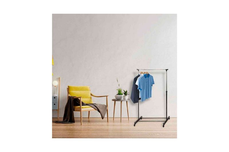 Perchero con ruedas regulable 84 x 42 x 165 cm Koopman, ambientado en habitación con ropa colgada y silla amarilla