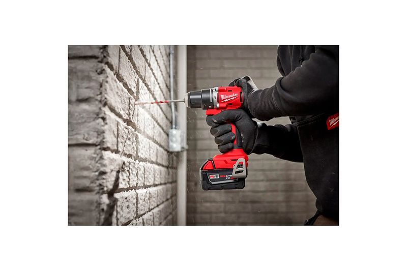 Taladro percutor inalámbrico Milwaukee de 1/2 pulgada y 18 V, siendo utilizado por una persona para perforar una pared