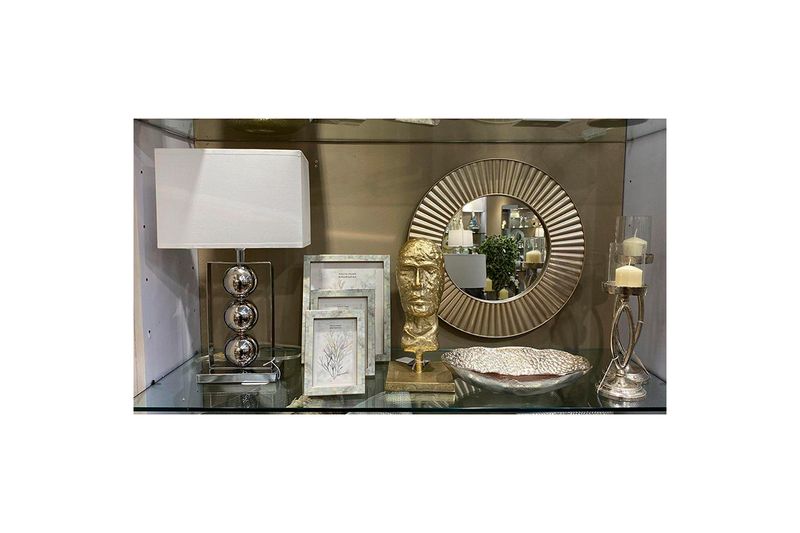Espejo decorativo redondo de 50 cm Concepts, colocado en un estante con lámpara, marcos y accesorios decorativos