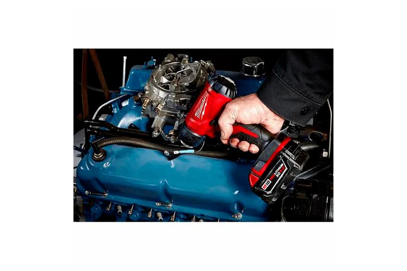Pistola de calor inalámbrica M18 sin batería Milwaukee, siendo utilizada sobre el motor azul de un vehículo