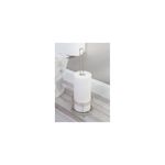 Portarrollo para papel higiénico satín Interdesign, colocado en el suelo junto a un inodoro con tres rollos de papel