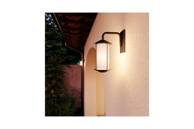 Luminaria de pared Neu Oriental 1L E27 marrón Blumenau, instalada en pared exterior encendida con luz cálida
