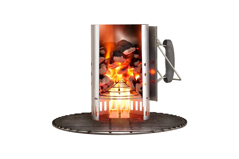 Chimenea para barbacoa de carbón Rapidfire Weber, vista frontal encendida con brasas rojas sobre base metálica circular