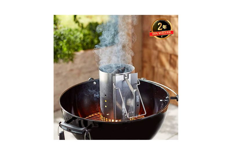 Chimenea para barbacoa de carbón Rapidfire Weber, en uso dentro de una parrilla negra emitiendo humo blanco