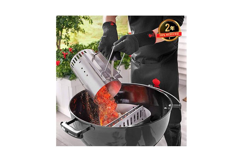 Chimenea para barbacoa de carbón Rapidfire Weber, persona vertiendo carbón encendido en una parrilla negra