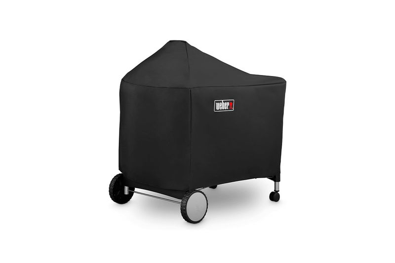 Funda para barbacoa Premium/Deluxe carbón negra Weber, puesta sobre la barbacoa con logo frontal y ruedas visibles