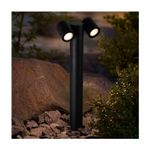 Mini poste Lebreles II 2L GU10 12W IP54 negro Tecnolite, instalado en jardín con rocas y luces encendidas