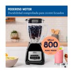 Licuadora vaso vidrio 1.5 l 800 w 2 vel negra Oster, imagen promocional con arándanos en el vaso y texto de potencia