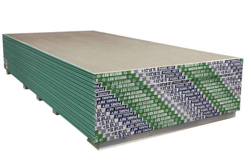 Lámina gypsum RH 4 x 8 x 1/2 Panel Rey, pila de láminas apiladas con bordes verdes y etiquetas laterales