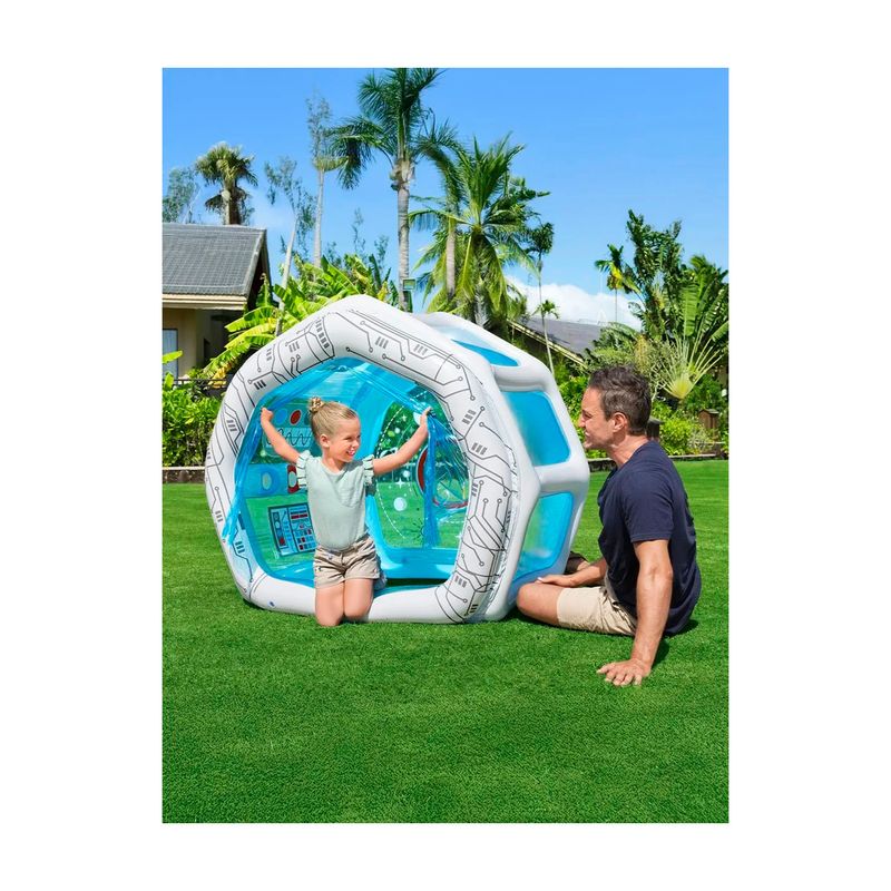 Juguete inflable nave espacial 1.25 x 1.05 x 1.17 m Bestway, niña jugando dentro y hombre sentado al lado en el césped