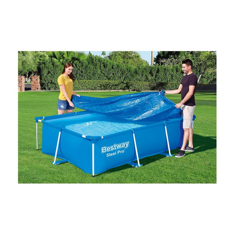 Lona protectora para piscina rectangular 3.00 x 2.01 m Bestway, pareja colocándola sobre una piscina azul en un jardín