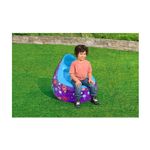 Sillón inflable para niños Astro Glow LED Bestway, niño sentado sobre el inflable morado con luces LED en el césped