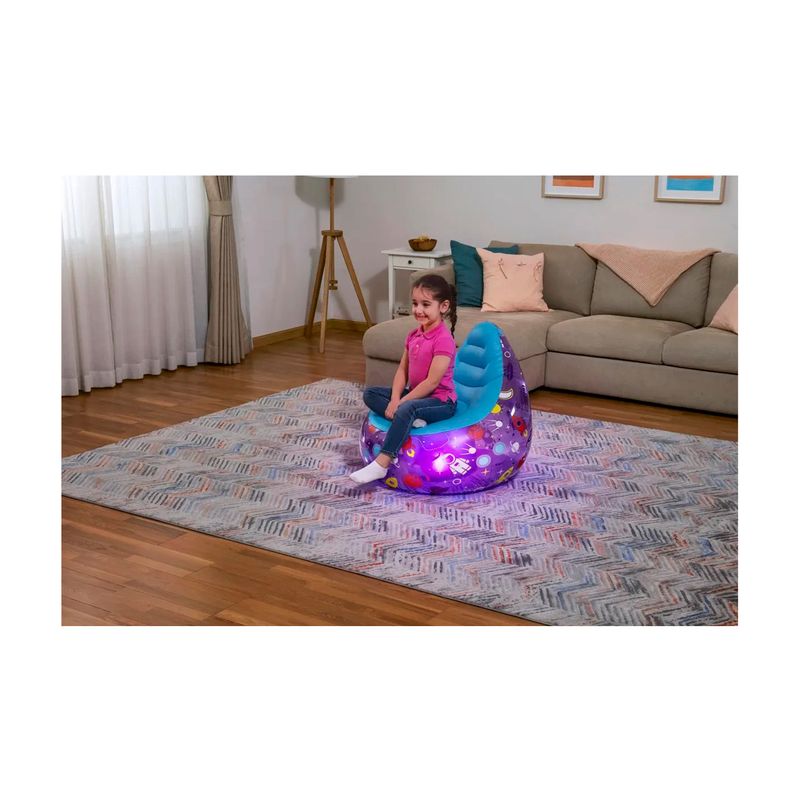 Sillón inflable para niños Astro Glow LED Bestway, niña sentada en el sillón iluminado con luces LED en una sala