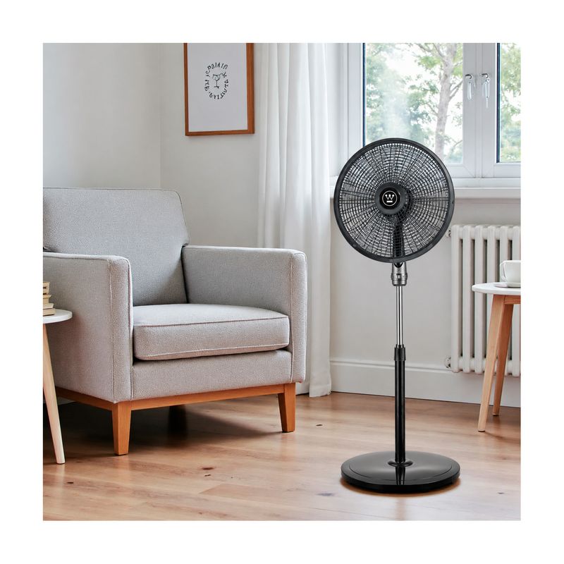 Abanico de pedestal 18 pulgadas 5A 3V 110V 70W negro Westinghouse, ubicado en una sala junto a un sillón gris