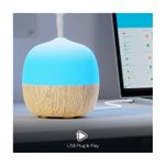 Difusor mini smart Nexxt, primer plano del equipo encendido con luz azul, emitiendo vapor y conectado a un cable USB