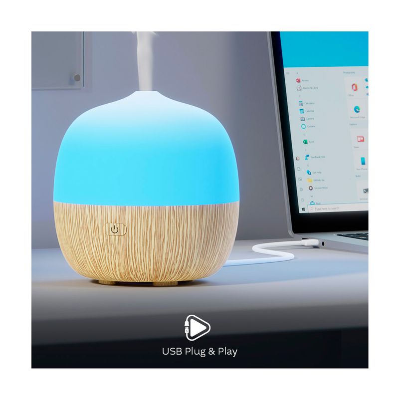 Difusor mini smart Nexxt, primer plano del equipo encendido con luz azul, emitiendo vapor y conectado a un cable USB