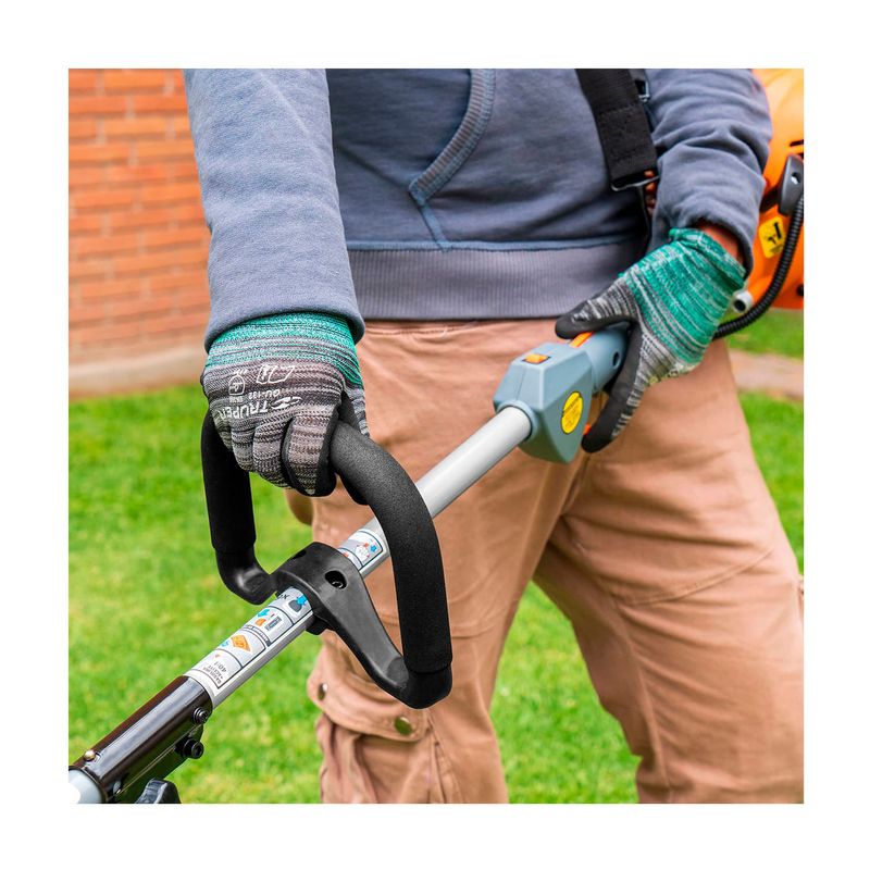 Desbrozadora gas 30 cc 17 pulgadas curva Truper, detalle del manubrio negro siendo sostenido por manos con guantes