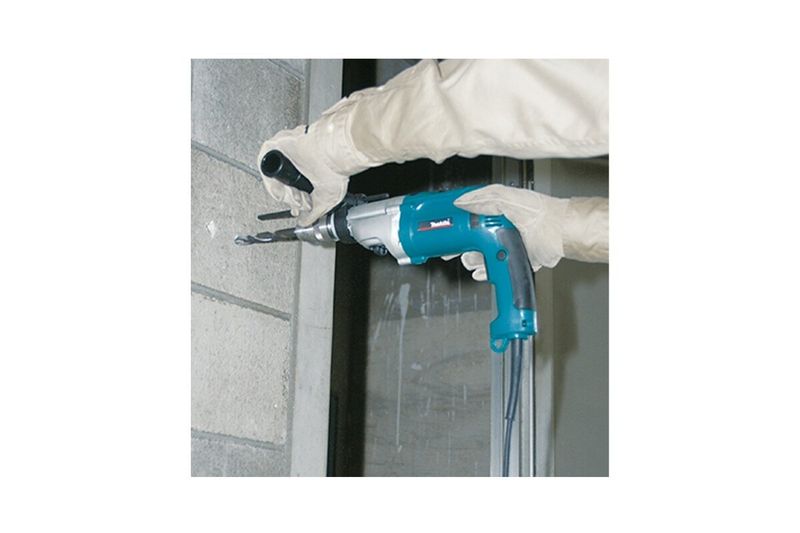 Taladro percutor eléctrico Makita de 3/4 pulgadas y 930 W, siendo utilizado para perforar una pared de concreto