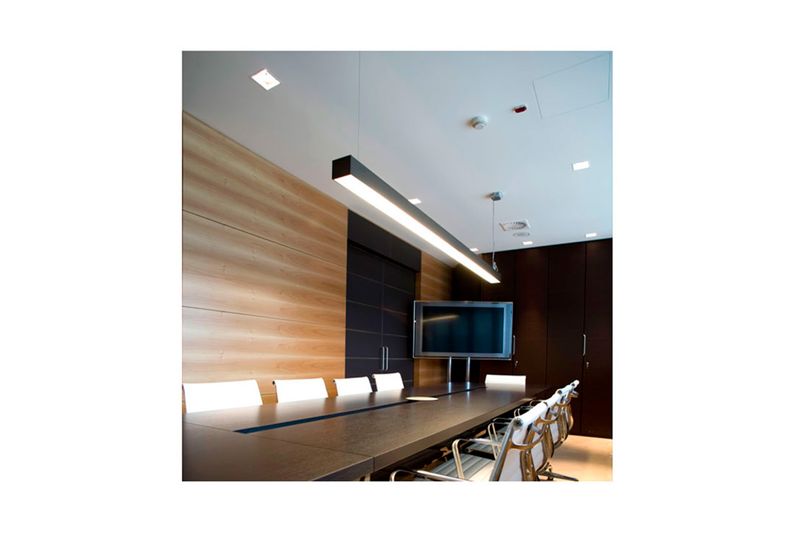 Luminaria lineal LED 48 pulgadas 2x18 W Sylvania, instalada en el techo de una oficina sobre una mesa de reuniones