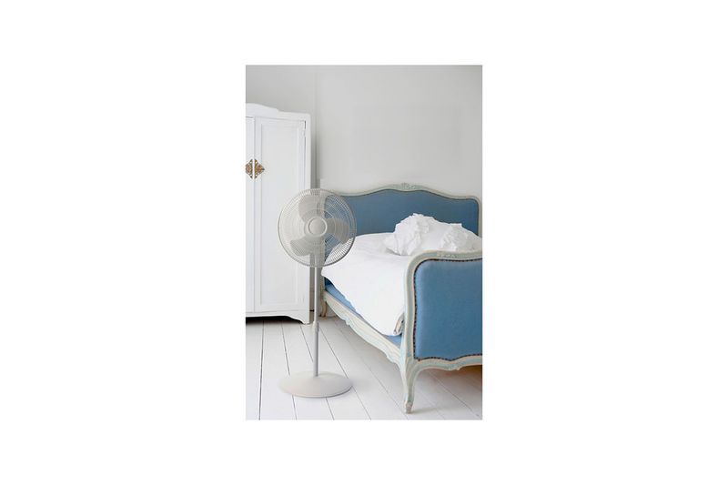 Abanico de pedestal 16 pulgadas 3 velocidades Lasko, ubicado en una habitación junto a una cama azul y blanco