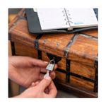 Candado aluminio Titalium 25 mm Abus, siendo abierto con su llave en un baúl de madera antiguo