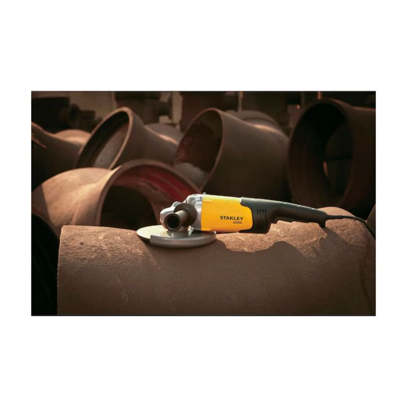 Esmeriladora angular eléctrica Stanley de 7 pulgadas y 2200 W, en uso sobre un tubo metálico oxidado