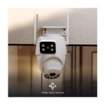 Cámara smart de exterior motorizada doble lente Nexxt, instalada en pared blanca con texto Motorized camera abajo