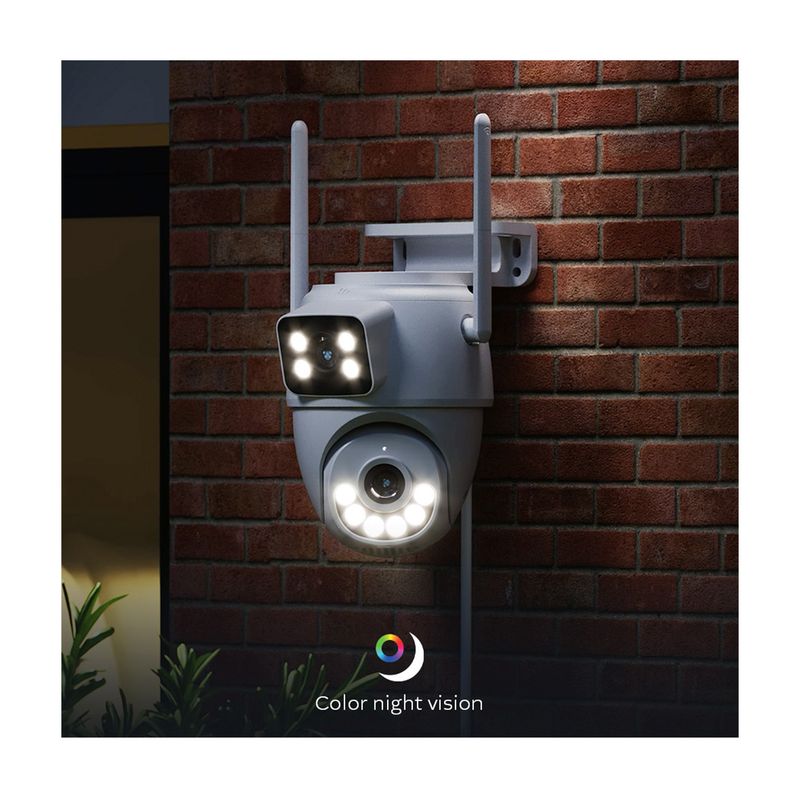 Cámara smart de exterior motorizada doble lente Nexxt, instalada en pared de ladrillos rojos con luces led encendidas