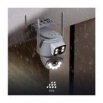 Cámara smart de exterior motorizada doble lente Nexxt, instalada en pared bajo la lluvia con sello IP65
