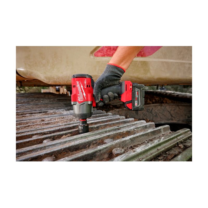 Kit de llave de impacto inalámbrica M18 Milwaukee de 1/2 pulgada, siendo utilizada por una persona sobre maquinaria pesada
